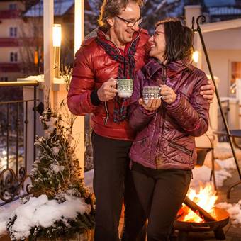 Couple drinks hot drink on a hotel terrace in winter
